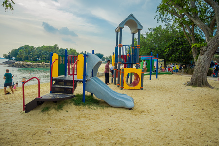 SINGAPORE, SINGAPORE - FEBRUARY 01, 2018: Unidentified people with their child in a playground located in the beach in Palawan Beach at Sentosa Island, Singaporeのeditorial素材