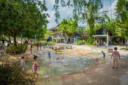 SINGAPORE, SINGAPORE - FEBRUARY 01, 2018: Beautiful outdoor view of children playing in the water with artificial fountains, close to the beach of Sentosa island in Singaporeのeditorial素材