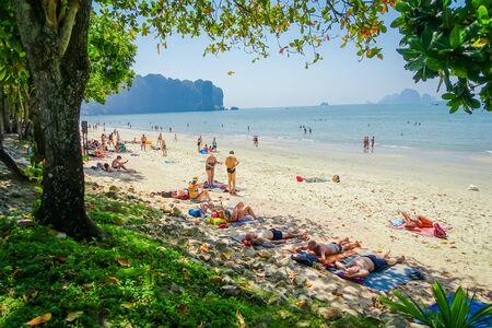AO NANG, THAILAND - MARCH 19, 2018: Outdoor view of unidentified people taking the sun in the sand at Ao Nang beach with the ocean at the horizontのeditorial素材