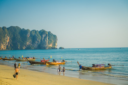AO NANG, THAILAND - MARCH 05, 2018: Outdoor view of unidentified people walking in the beach close to Fishing thai boats at Po-da island, Krabi Province, Andaman Sea, South of Thailandのeditorial素材