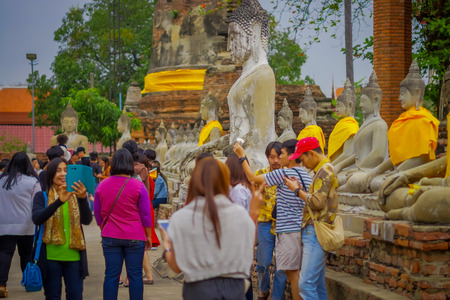 AYUTTHAYA, THAILAND, FEBRUARY, 08, 2018: Outdoor view of unidentified people at Ancient Buddha Statue covered with yellow fabric at WAT YAI CHAI MONGKOL, The Historic City of Ayutthayaのeditorial素材