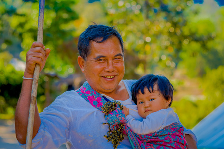 CHIANG RAI, THAILAND - FEBRUARY 01, 2018: Close up of man holding in his arm a baby in a Jungle Sanctuary at Chiang Mai, during a gorgeous sunny dayのeditorial素材