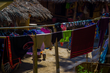 Outdoor view of clothes drying in the sun Long Neck tribe, Kayan Lahwi, with taditional houses aroundの写真素材