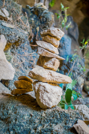 Close up of selective focus of small rocks one over other in equilibrium at the enter of ancient cave Tham Pee Hua Toe or Big-headed Ghost Cave in Krabi province, Thailandの写真素材