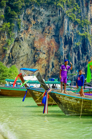 PHRA NANG, THAILAND - FEBRUARY 09, 2018: Outdoor view of native people at long tail boats in a shore on Phra nang island in a gorgeous sunny day and turquoise waterのeditorial素材
