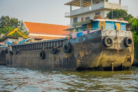 BANGKOK, THAILAND - FEBRUARY 09, 2018: Rusted a old boat at riverside with neumatics hanging, at yai canal or Khlong Bang Luang Tourist Attraction in Thailandのeditorial素材