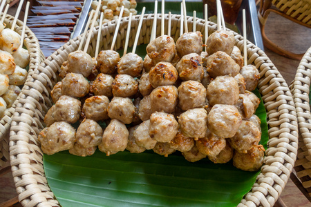 Close up of meat brochette over a straw tray at food street market at Khao San Road, this road is popular among backpacker because budget accommodation and foodの写真素材