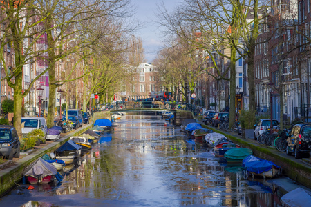 AMSTERDAM, NETHERLANDS, MARCH, 10 2018: Beautiful outdoor view of houses and Boats on Amsterdam Canalのeditorial素材