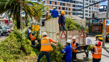 QUITO, ECUADOR - FEBRUARY 26, 2018: Outdoor view of EPMMOP workers cleaning and picking up pieces of...