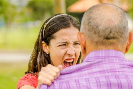 Close up of daughter arguing with his father at outdoorsの写真素材
