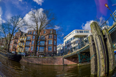 AMSTERDAM, NETHERLANDS, MARCH, 10 2018: Beautiful outdoor view of apartment buildings with abridge over a canal in the city of Amsterdamのeditorial素材