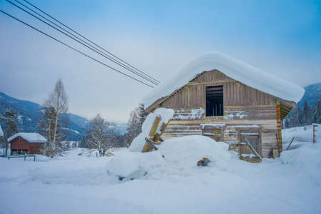 Outdoor view of traditional Norwegian mountain houses of wood covered with snow in stunning nature in Norwayの写真素材