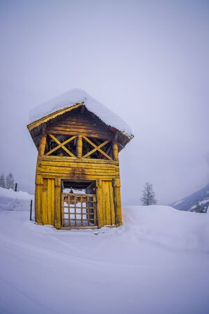 Outdoor view of traditional Norwegian mountain cabins of wood covered with snow in a winter season in Norwayの写真素材