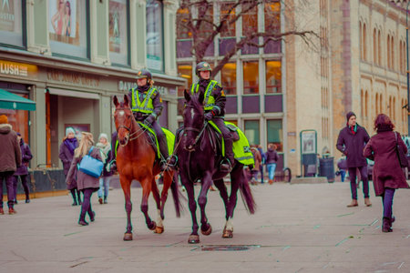 OSLO, NORWAY - MARCH, 26, 2018: Outdoor view of police on horse in Oslo city, close to unidentified...