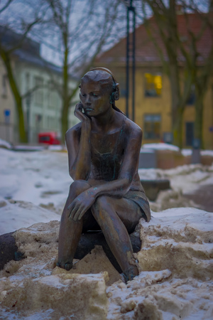 OSLO, NORWAY - MARCH, 26, 2018: Outdoor view of seated girl with headphones statue in the streets of Osloのeditorial素材
