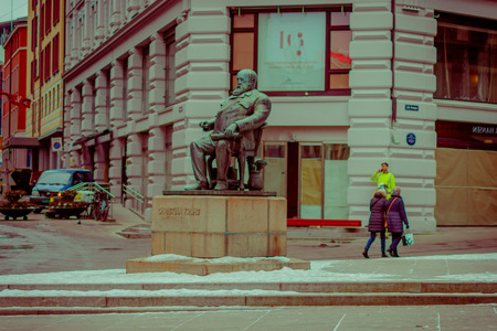 OSLO, NORWAY - MARCH, 26, 2018: Outdoor view of people walking close to statue of Christian Krohg on Karl Johans, was a Norwegian naturalist painter, illustrator, author and journalistのeditorial素材
