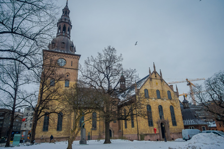 OSLO, NORWAY - MARCH, 26, 2018: Outdoor view of Domkirke Cathedral in Oslo with some dry trees in front at Osloのeditorial素材