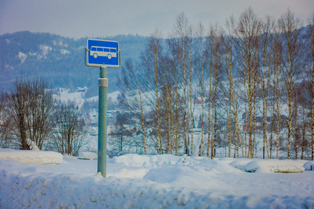Valdres, Norway - March 26, 2018: Outdoor view of sign of bus stop at one side during winter in the road, with snow and ice in the forest of Norwayのeditorial素材