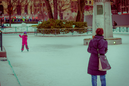 OSLO, NORWAY - MARCH 8, 2017: Outdoor view of unidentified woman with her daugher playing in the snow in Vigeland Park on a breezy winter dayのeditorial素材