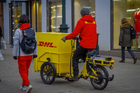 OSLO, NORWAY - MARCH, 26, 2018: Outdoor view of unidentified man riding a yellow trycicle od DHL in the streets of Oslo cityのeditorial素材