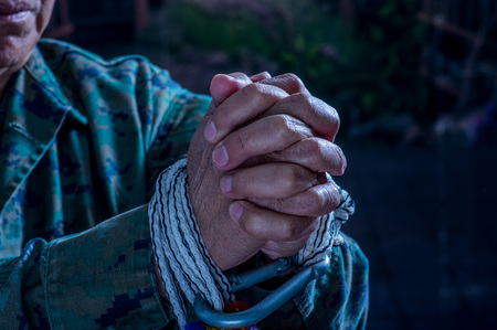 Close up of man hands wrapped with rope around wrists in captivity , victim abused, slave of work, respect for human rights and exploitation concept isolated on blurred backgroundの写真素材