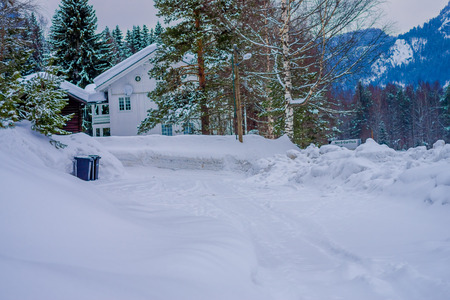 Reinli, Norway - March 26, 2018: Outdoor view of traditional wooden white house with snow in the roof in stunning nature background in Valdres regionのeditorial素材