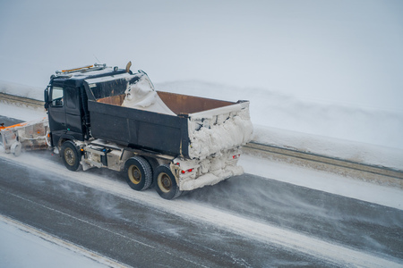 Reinli, Norway - March 26, 2018: Above view of snow-removing machine cleans the street from the snow in the morning covered trees and roadsのeditorial素材