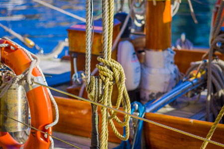 ALESUND, NORWAY - APRIL 04, 2018: Outdoor view of ropes around a lifesaver of color oragnge in the city of Alesund with tour boat and old sail boatのeditorial素材
