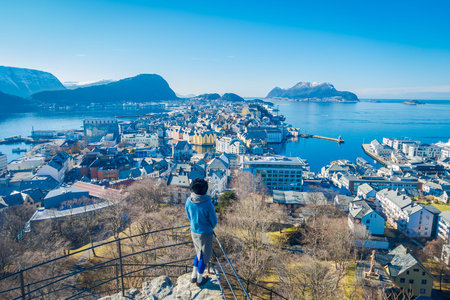 ALESUND, NORWAY - APRIL 04, 2018: People posing for picture from the birds eye view of Alesund port town on the west coast of Norway, at the entrance to the Geirangerfjordのeditorial素材