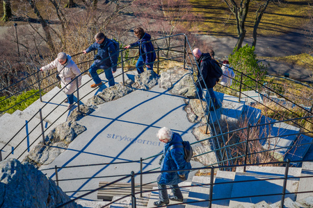 ALESUND, NORWAY - APRIL 04, 2018: People walking upstairs to enjoy the view from byrampen viewer of Alesund port town on the west coast of Norway, at the entrance to the Geirangerfjordのeditorial素材