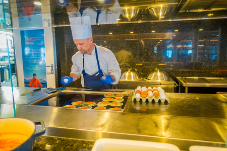 ALESUND, NORWAY - APRIL 04, 2018: Indoor view of cheff man cooking in a luxury kitchen inside of Hurtigruten voyage in cruise along Norwegian coastのeditorial素材
