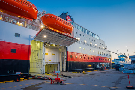 ALESUND, NORWAY - APRIL 06, 2018: View of vessel KONG HARALD with doors opened to put the luggage inside, is a daily passenger and freight shipping service along Norway between Bergen and Kirkenesのeditorial素材