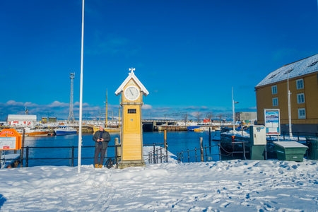 TRONDHEIM, NORWAY - APRIL 04, 2018: Outdoor view of tourist man close to a wooden yello hut cock in the marina port in Trondhemのeditorial素材