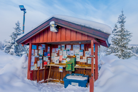 Bagnsasen, Norway - April, 02, 2018: Outdoor view of wooden hut building with informative signs with heavy snow, and pine trees in the forestのeditorial素材