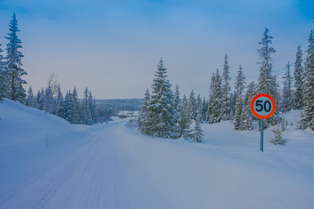 Bagnsasen, Norway - April, 02, 2018: Outdoor view of street sign of speed limit at one side during winter in the road, with snow and iceのeditorial素材