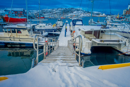 Bodo, Norway - April 09, 2018: Outdoor view of floating pier covered with snow at the enter to the...