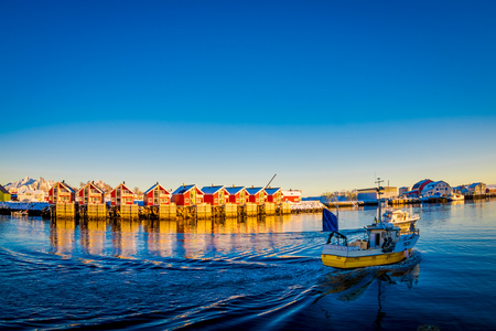 SVOLVAER, LOFOTEN ISLANDS, NORWAY - APRIL 10, 2018: Landscape of Svolvaer village buildings in the seaside with boats sailing, during a sunny day with clear blue sky in the Lofoten Islandsのeditorial素材