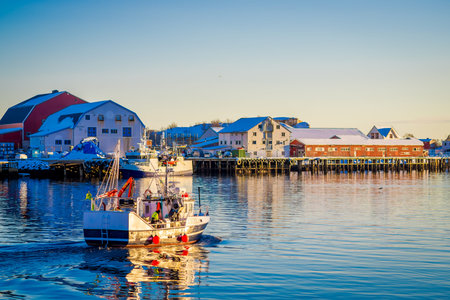 SVOLVAER, LOFOTEN ISLANDS, NORWAY - APRIL 10, 2018: Landscape of Svolvaer village buildings in the seaside with boats sailing, during a sunny day with clear blue sky in the Lofoten Islandsのeditorial素材