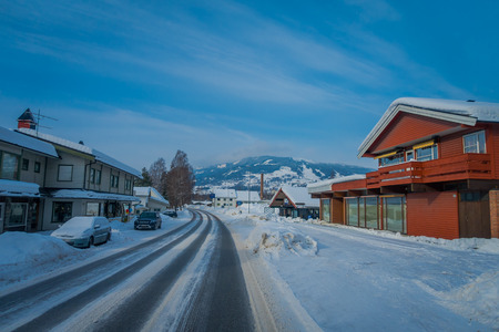 GOL, NORWAR, APRIL, 02, 2018: Outdoor view of wooden building located at one side of the road, covered with snow in GOLのeditorial素材
