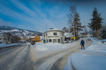 GOL, NORWAR, APRIL, 02, 2018: View of woman walking to the building of veterinary located in dowtown between two streets in a Y intersection covered with snow during winter in GOLのeditorial素材