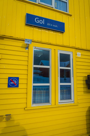 GOL, NORWAR, APRIL, 02, 2018: Outdoor view of wooden yellow building with a glass window, and informative sign of not smoking in GOLのeditorial素材