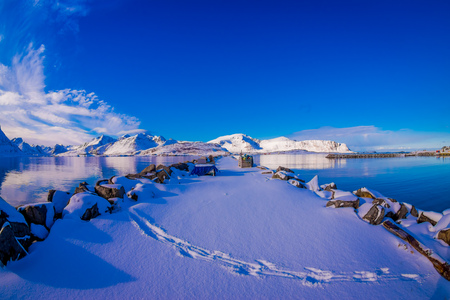 Outdoor scenic view with rocks covered with snow close to a lake in Svolvaerの写真素材