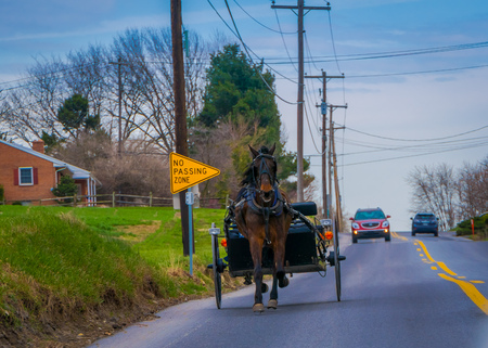 LANCASTER, USA - APRIL, 18, 2018: Outdoor view of Amish horse and carriage travels on a roadのeditorial素材