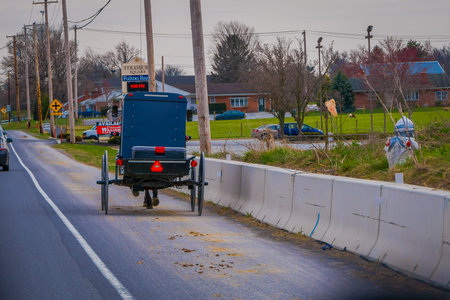 LANCASTER, USA - APRIL, 18, 2018: Outdoor view of the back of old fashioned Amish buggy with a horse...