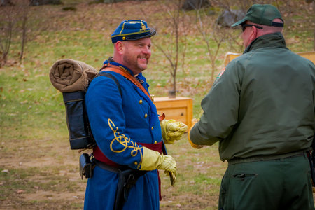 MOORPARK, USA - APRIL, 18, 2018: Man with blue uniform, backpack and holding a sword talking with...