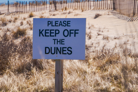 LONG ISLAND, USA, APRIL, 04, 2018: Outdoor view of informative sign of please keep off the dunes located at outdoors of the beach at Long islandのeditorial素材