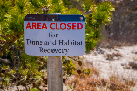 LONG ISLAND, USA, APRIL, 04, 2018: Outdoor view of informative sign of area closed for dunes and habitat recovery located at outdoors of the beach at Long islandのeditorial素材