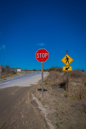 LONG ISLAND, USA, APRIL, 04, 2018: Outdoor view of informative sign of STOP, located at one side of the road with yellow sign at one side of the road in the beach at Long islandのeditorial素材