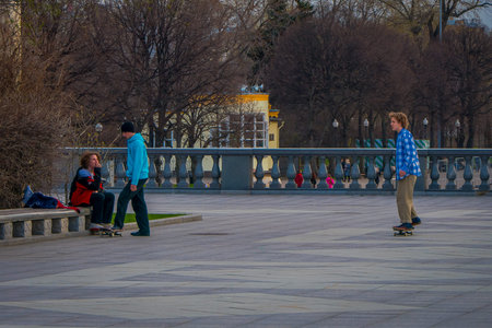 MOSCOW, RUSSIA- APRIL, 24, 2018: Outdoor view of teenagers practicing roller skating in a park...