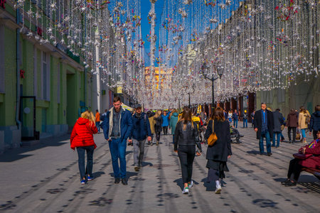 MOSCOW, RUSSIA- APRIL, 24, 2018: Outdoor view of unidentified people walking under a festive Christmas lights on Nikolskaya streets in a sunny dayのeditorial素材